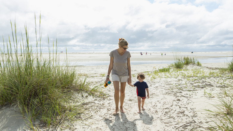 Mom and child walking on the beach